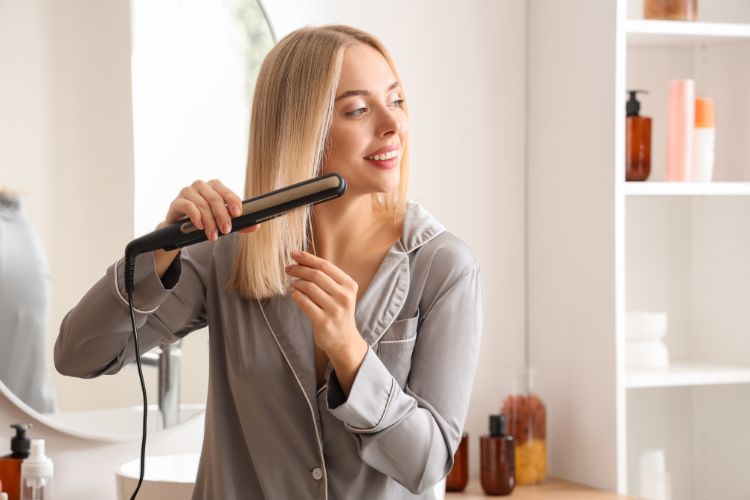 mujer planchandose el pelo con una plancha de pelo