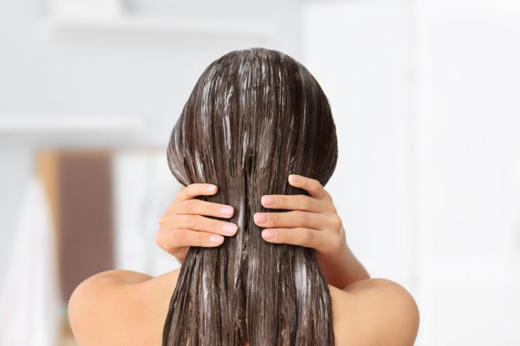 mujer aplicandose mascarilla en el cabello