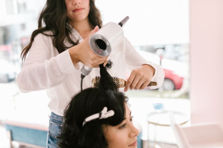 peluquera secando pelo con secador profesional